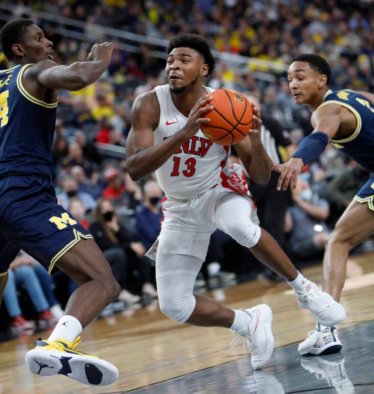 UNLV Rebels guard Bryce Hamilton (13) tries to drive past Michigan Wolverines forward Moussa Di ...