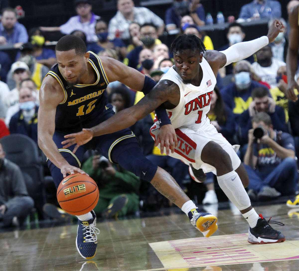 Michigan Wolverines guard DeVante' Jones (12) keeps a ball away from UNLV Rebels guard Michael ...