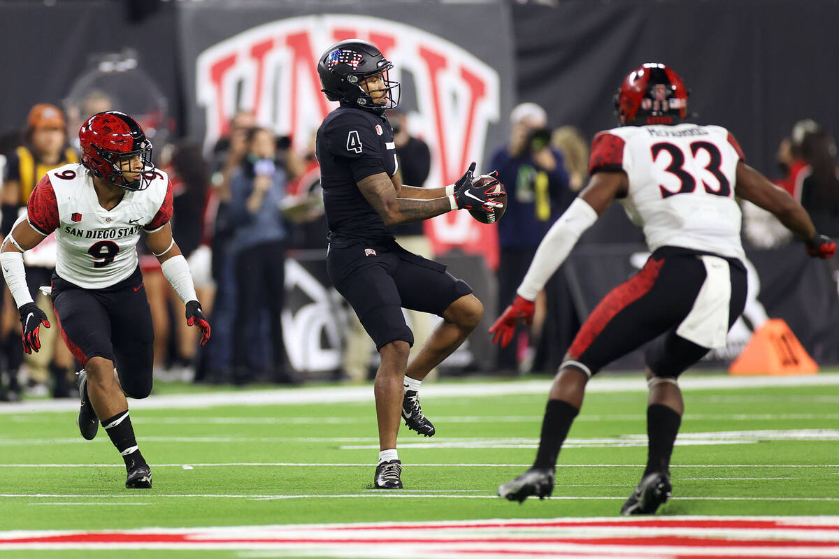 UNLV Rebels wide receiver Steve Jenkins (4) makes a attach under pressure from San Diego State ...