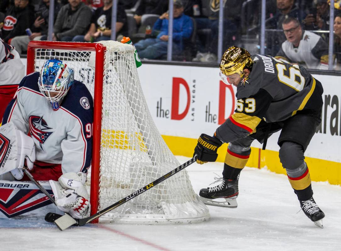 Golden Knights right wing Evgenii Dadonov (63) attempts to sneak the puck past Columbus Blue Ja ...