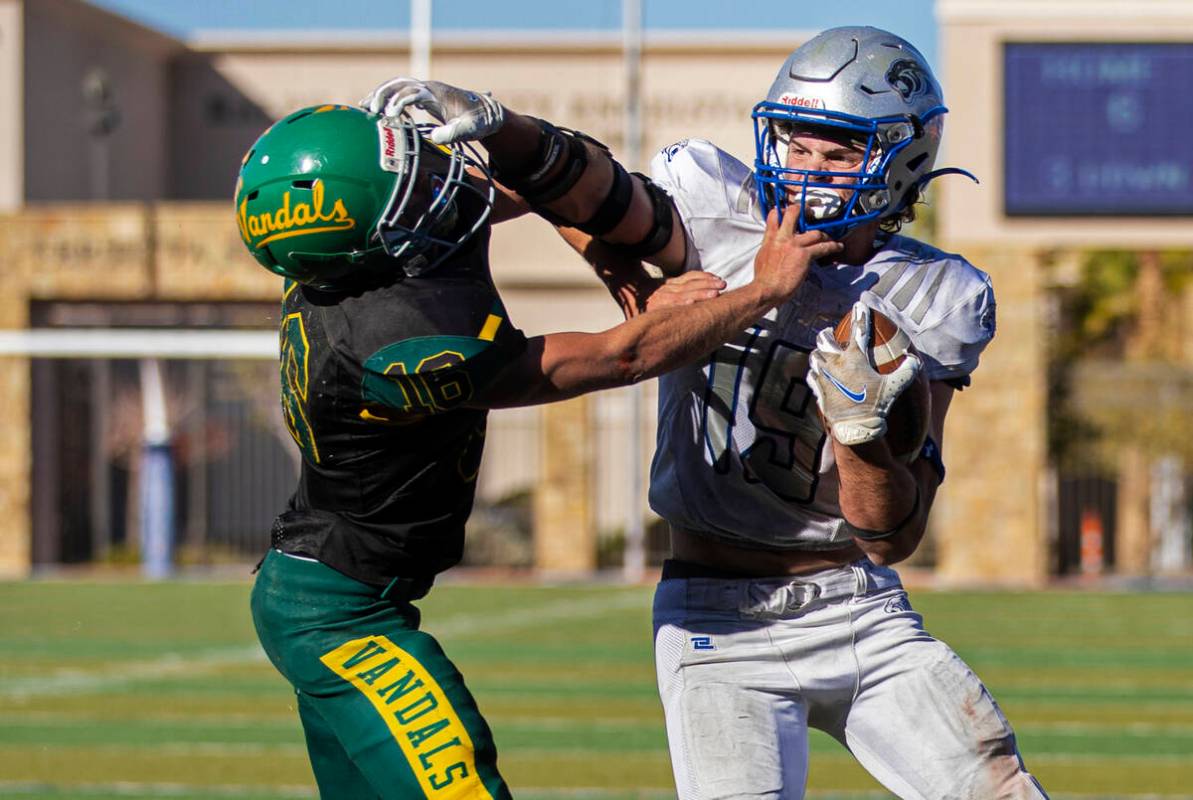 Pahranagat Valley’s Paul Lewis (19) stiff arms Eureka’s Clayton Shoda (16) in the ...