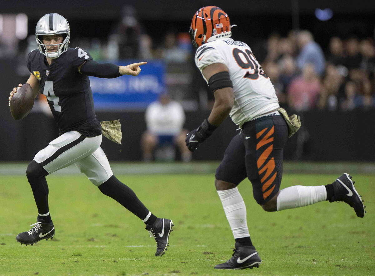 Raiders quarterback Derek Carr (4) directs traffic with Cincinnati Bengals defensive tackle Tyl ...