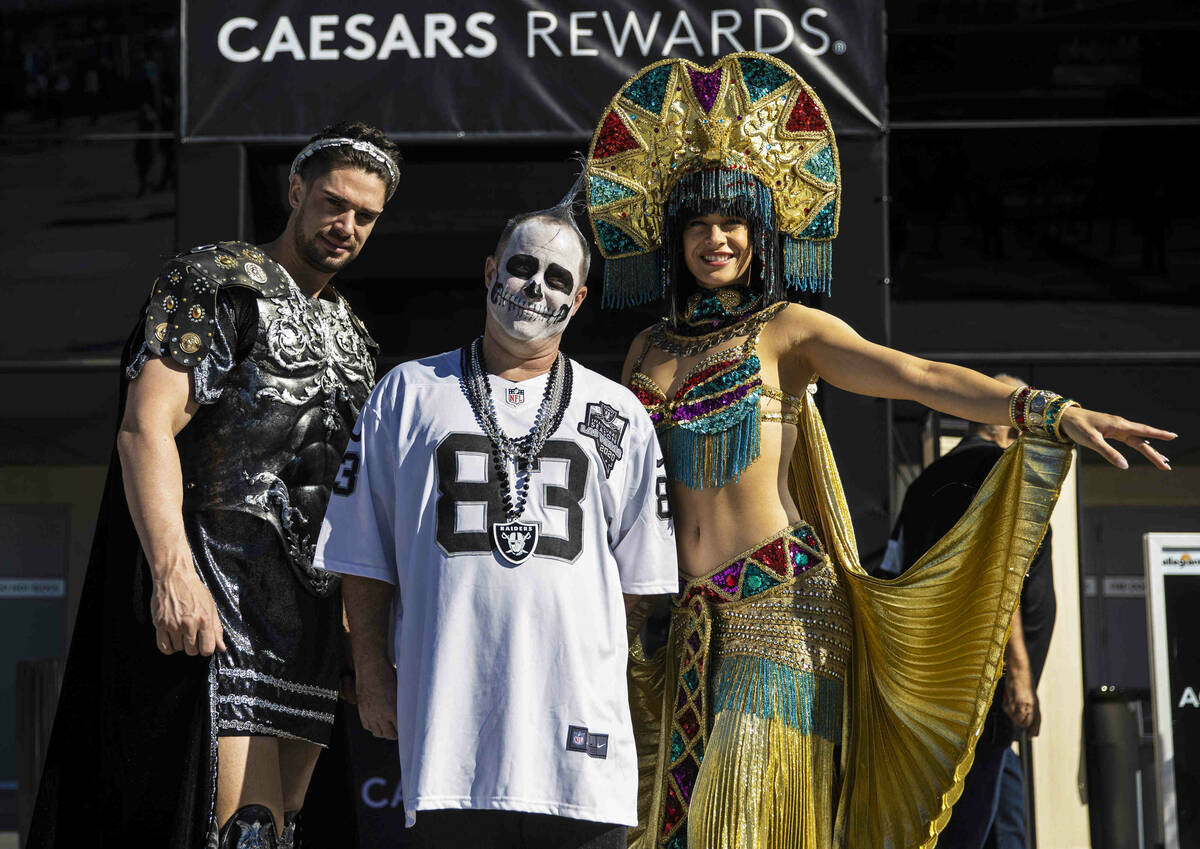 Raiders fan Graham MacDonald, middle, outside Allegiant Stadium before the start of an NFL foot ...