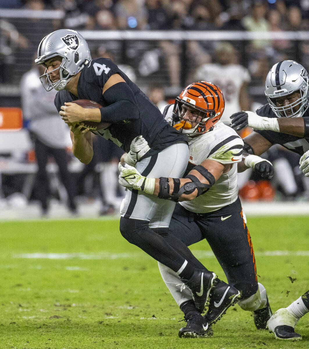Raiders quarterback Derek Carr (4) is sacked by Cincinnati Bengals defensive end Sam Hubbard (9 ...