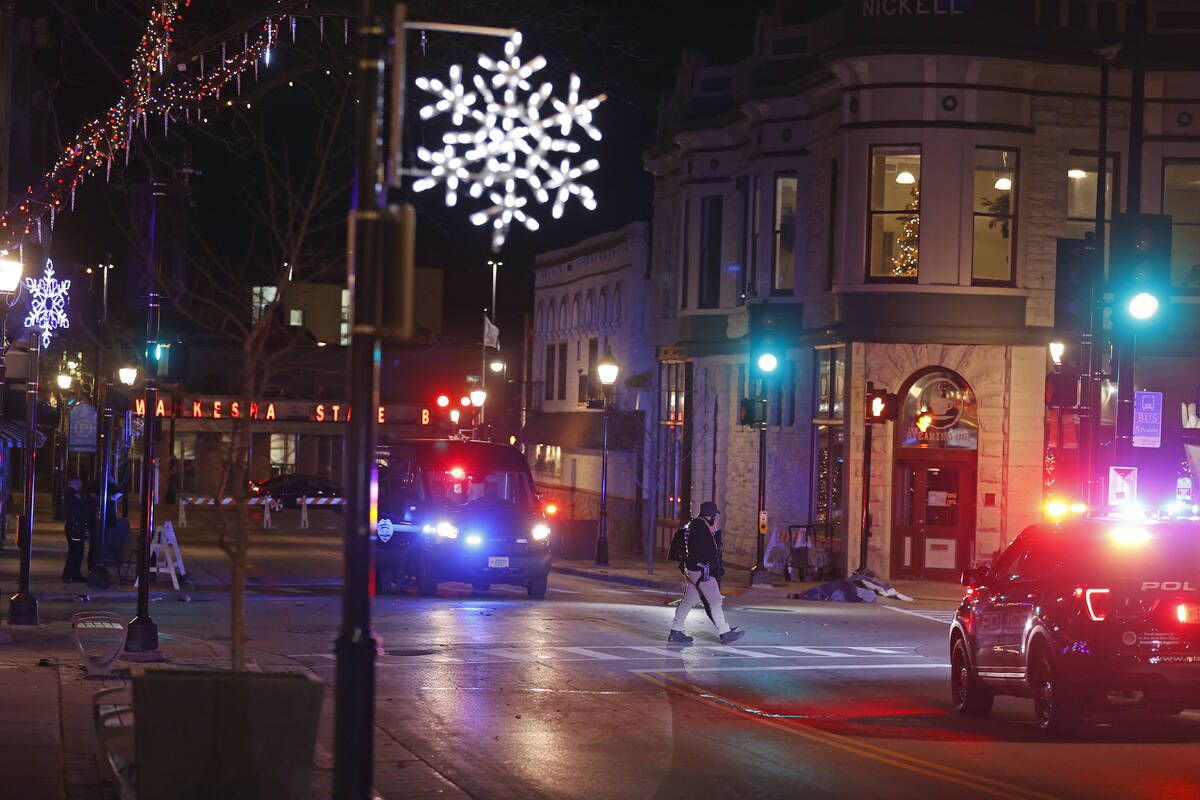 Police canvass the streets in downtown Waukesha, Wis., after a vehicle plowed into a Christmas ...