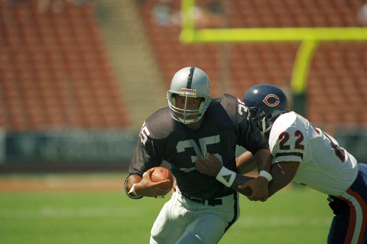 Los Angeles Raiders running back Steve Smith (35) grits his teeth as he attempts to gain more y ...