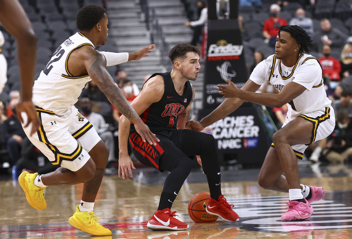 UNLV Rebels guard Jordan McCabe (5) brings the ball up court between Wichita State Shockers gua ...