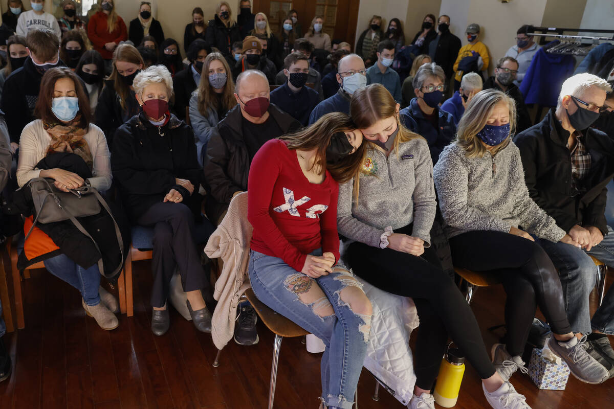 A woman leans on a friend during a prayer vigil at Carroll University in Waukesha, Wis., Monday ...