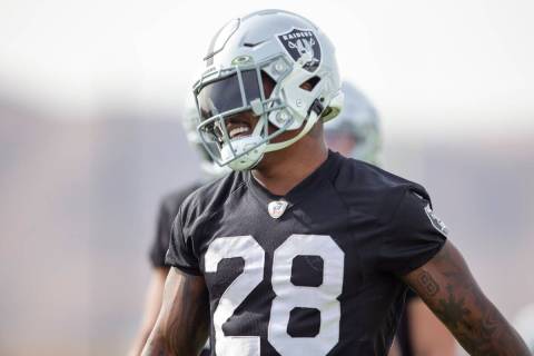 Raiders running back Josh Jacobs (28) walks on the field smiling during a practice session at R ...