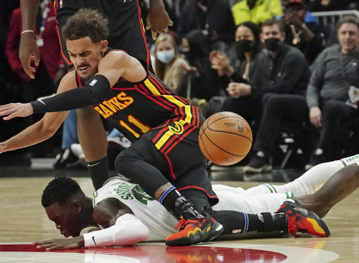 Atlanta Hawks guard Trae Young (11) and Boston Celtics guard Dennis Schroder (71) scramble for ...