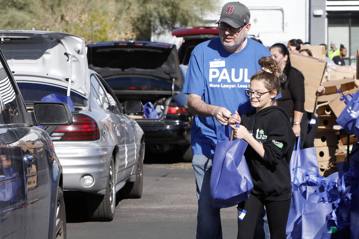 Gianna Marcolongo, 12, of Las Vegas helps to give away turkeys with her father Dana during Paul ...
