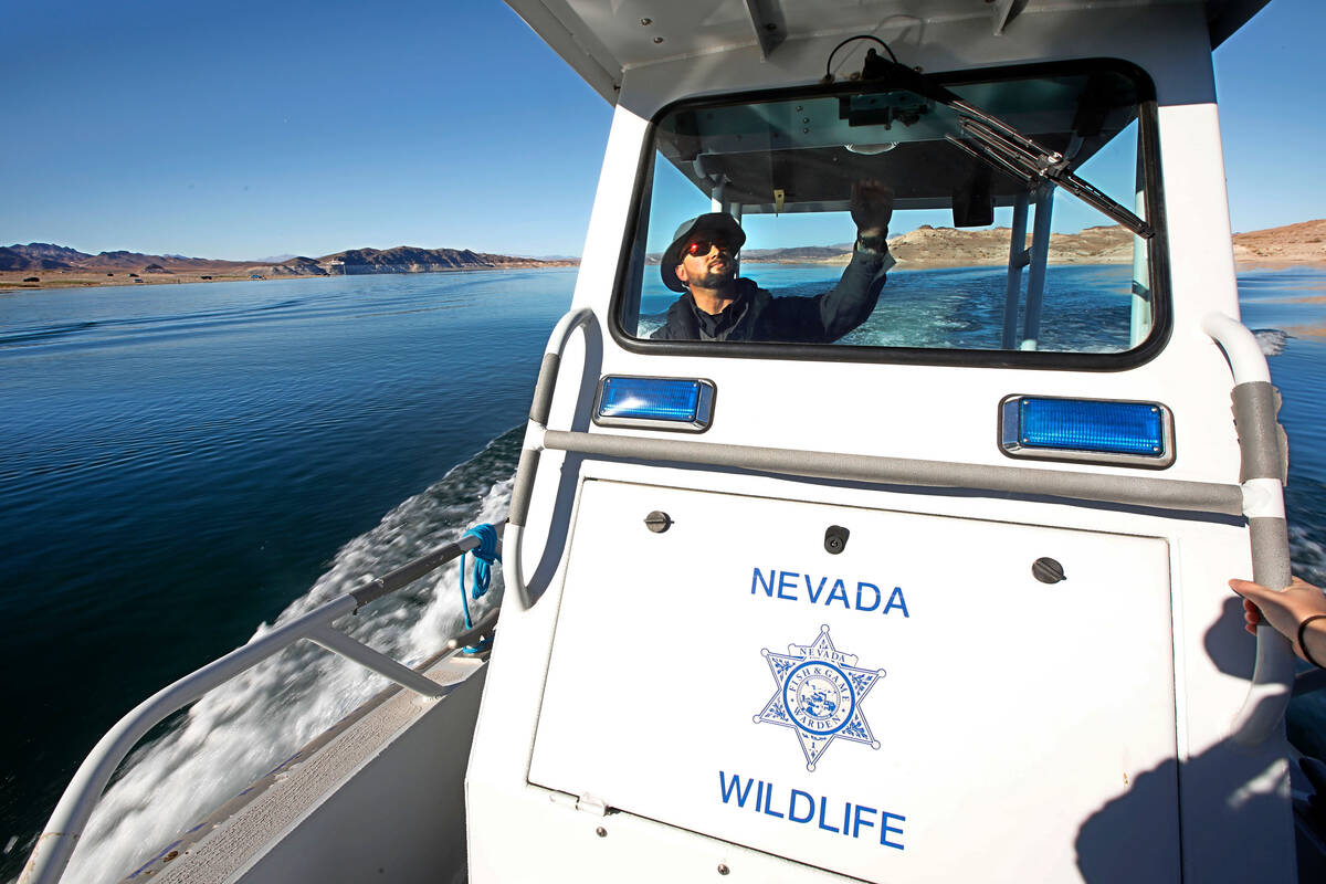 Sean Flynn, Nevada Department of Wildlife game warden, navigates a boat while he patrols Lake M ...