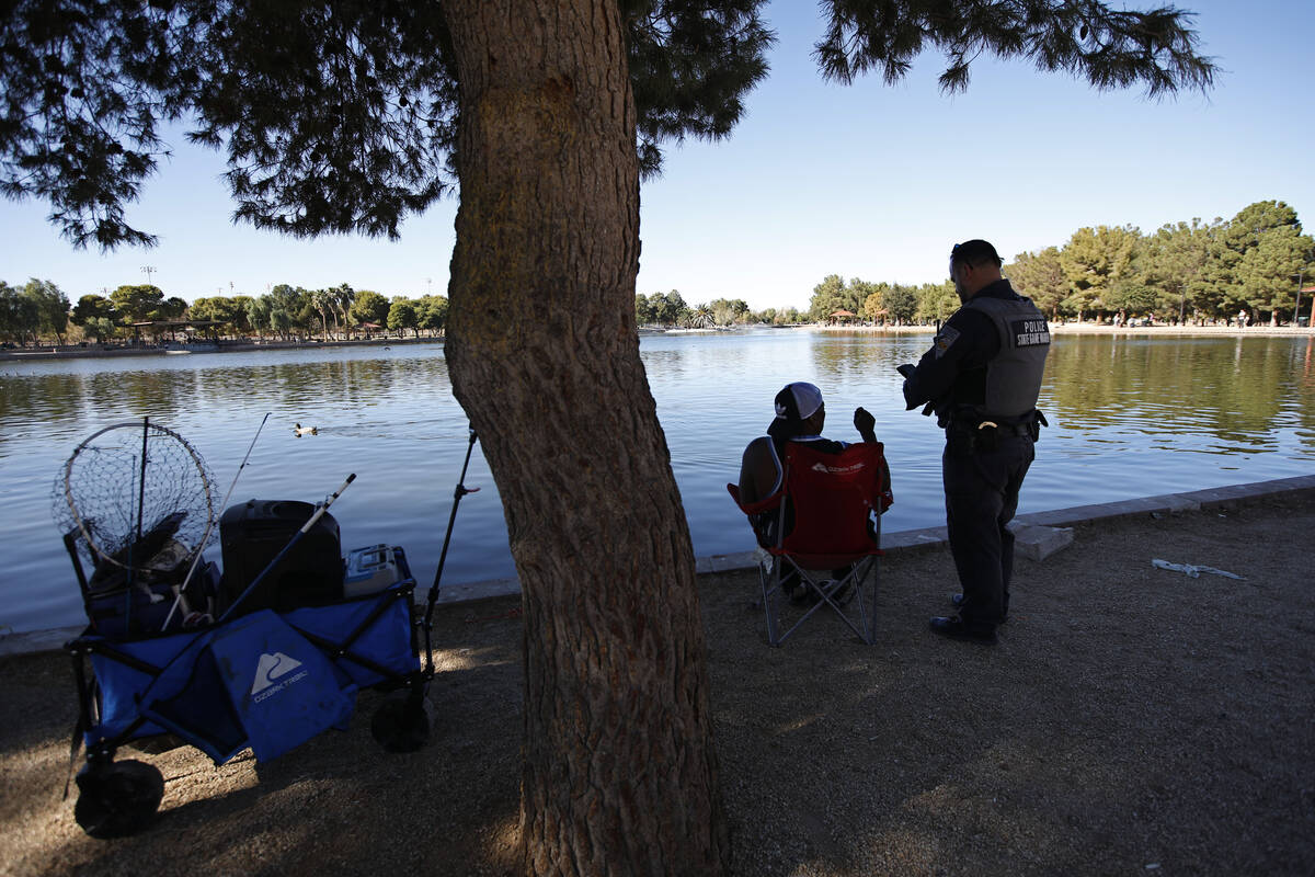 Sean Flynn, Nevada Department of Wildlife game warden, right, talks with a fisherman while he p ...