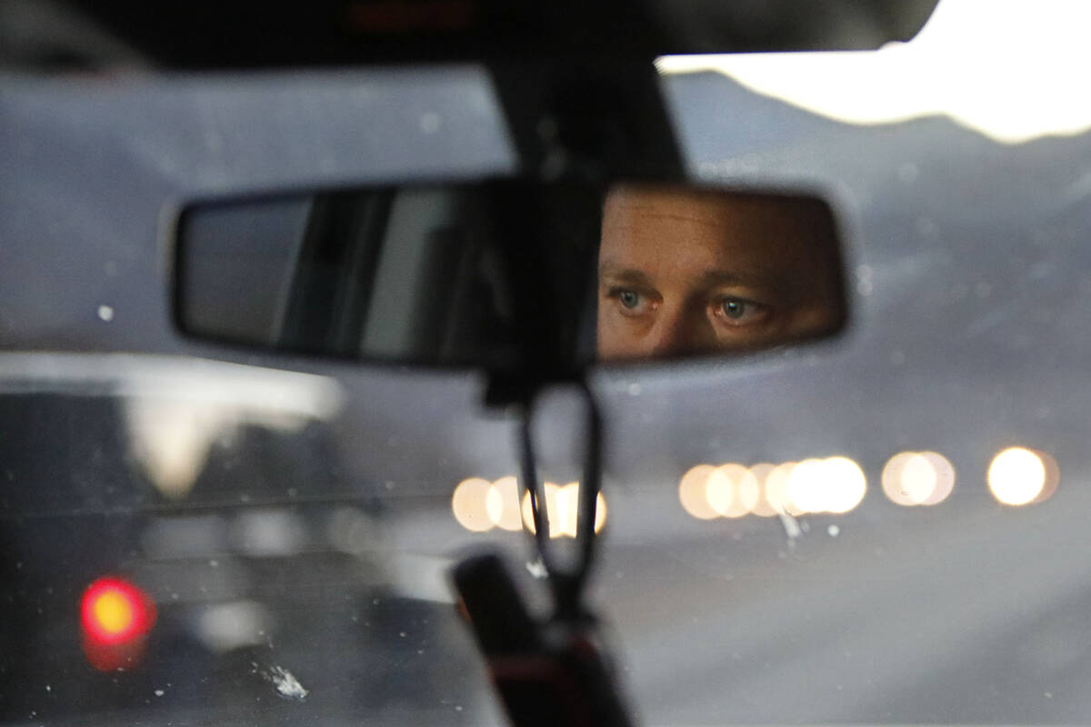 Sean Flynn, Nevada Department of Wildlife game warden, is reflected in the rear view mirror whi ...