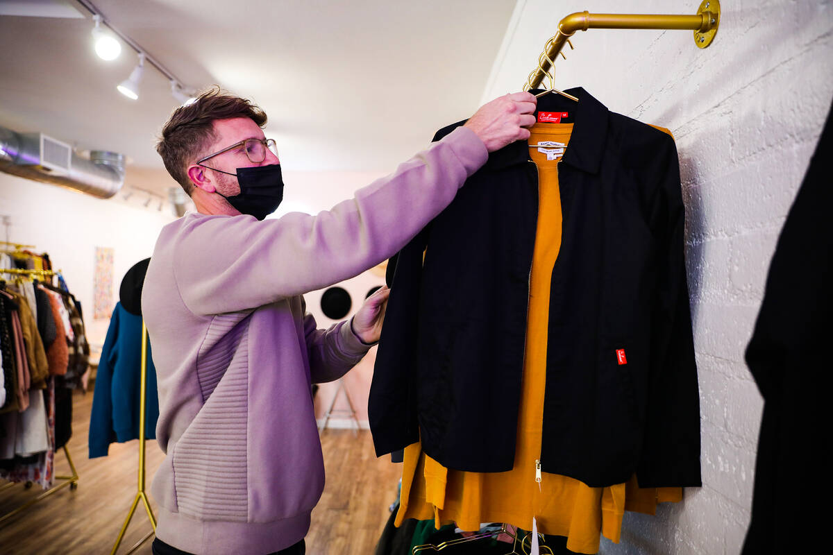Nate Johnson, owner of the boutique clothing store For the love, LV, hangs a jacket at the stor ...