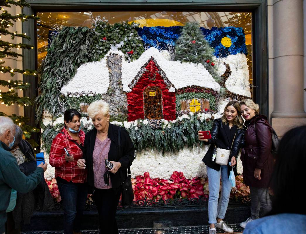 Tourists pose for a photo at The Bellagio Conservatory's holiday display "Holiday Time" on Tues ...