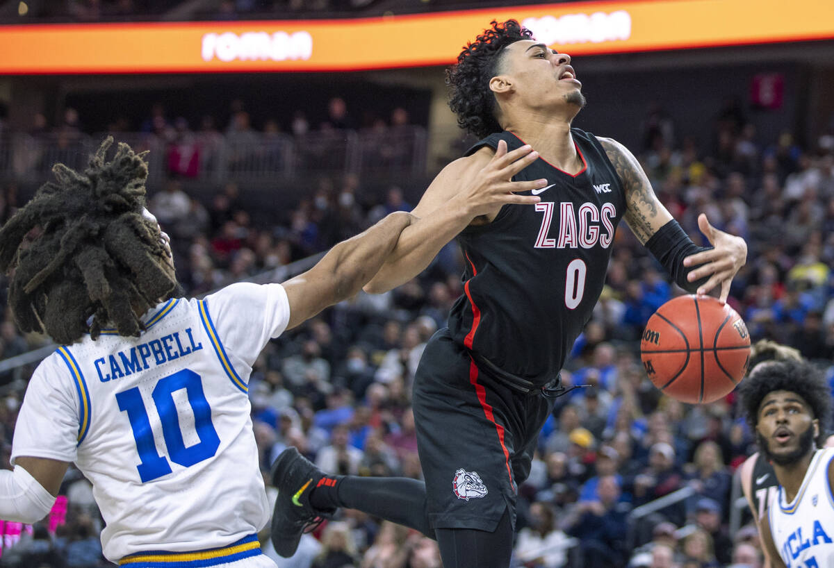 UCLA guard Tyger Campbell (10) fouls Gonzaga guard Julian Strawther (0) on a drive to the baske ...