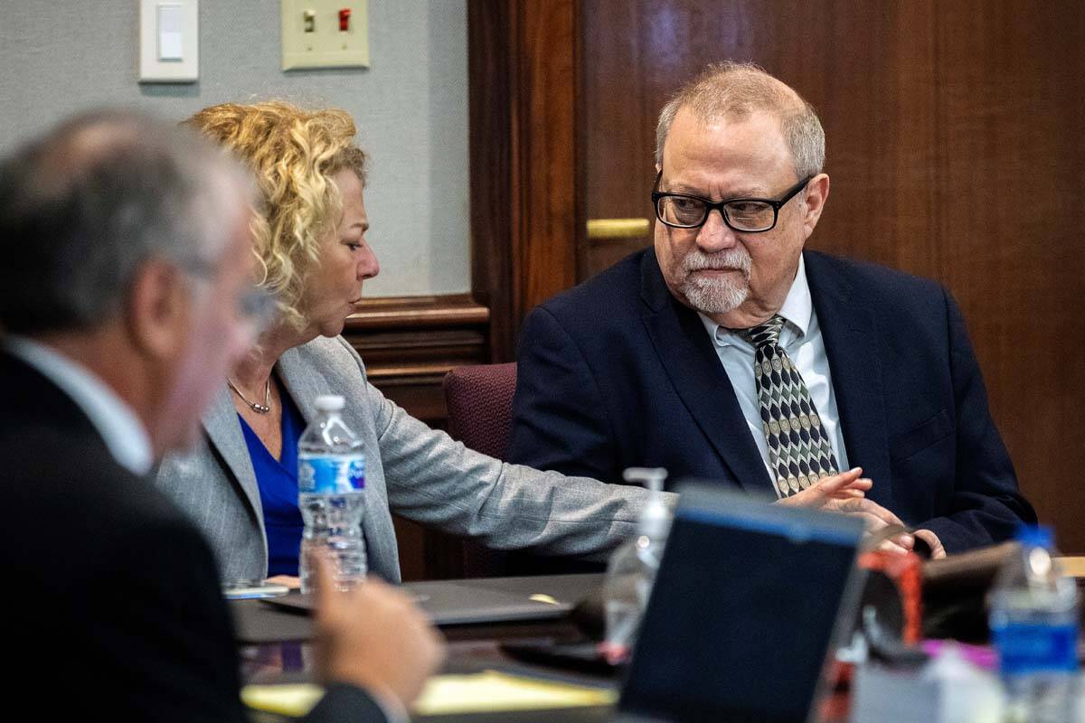 Defense attorney Laura Hogue, center, touches the hand of her client Greg McMichael, right, whi ...