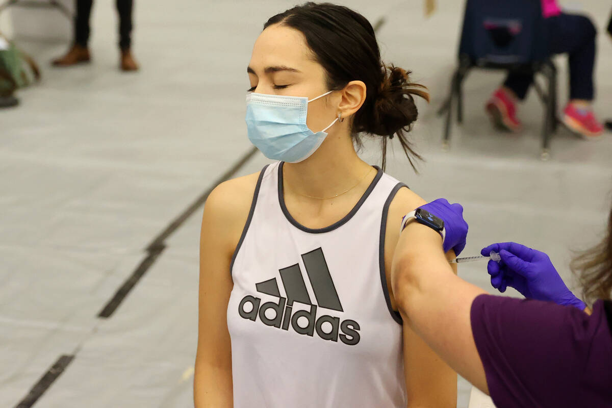 Ursula Moreno of Las Vegas receives the COVID-19 vaccine as her husband Keenan Laffoon and 11-m ...