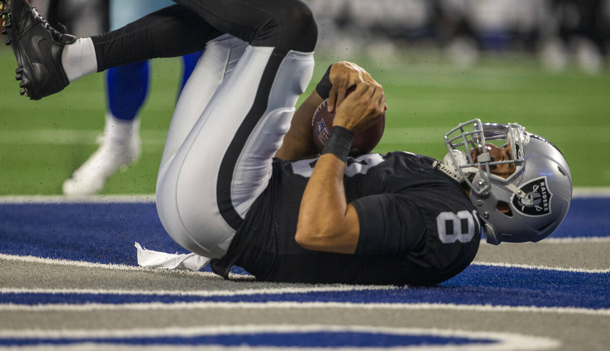 Raiders quarterback Marcus Mariota (8) holds on to the football after scoring against the Dalla ...