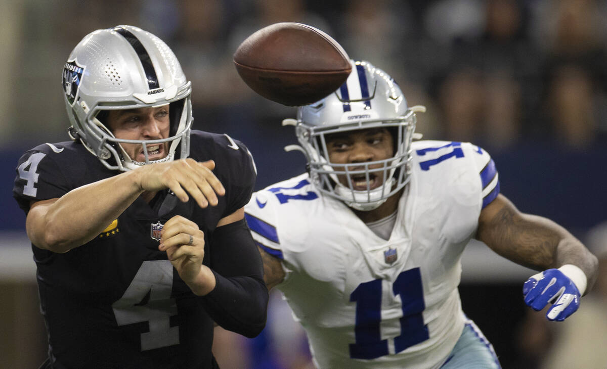 Raiders quarterback Derek Carr (4) gets rid of the ball at the last second with pressure from D ...