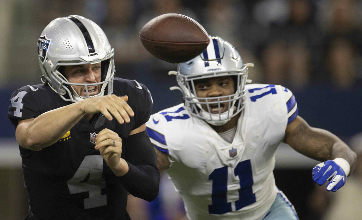 Raiders quarterback Derek Carr (4) gets rid of the ball at the last second with pressure from D ...
