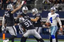 Dallas Cowboys quarterback Dak Prescott (4) walks near as Raiders defensive end Maxx Crosby (98 ...