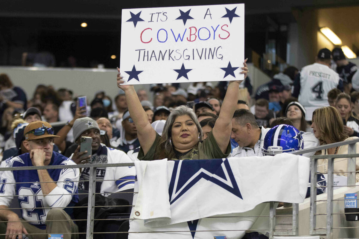 A Dallas Cowboys fan holds up a sign before an NFL football game against the Raiders on Thursda ...