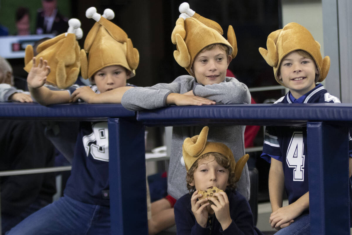 Young Dallas Cowboys fans wear turkey hats before an NFL football game against the Raiders on T ...