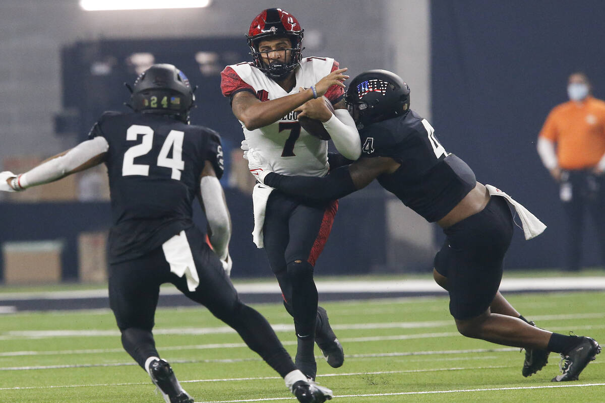 San Diego State quarterback Lucas Johnson (7) is tackled by UNLV linebacker Jacoby Windmon (4) ...