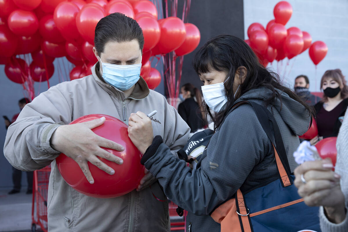 Dale Zalewski, left, and Sandra Zalewski write a message on a balloon during a vigil to the lat ...