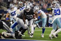 Raiders running back Josh Jacobs (28) leaps into the end zone in the first half during an NFL f ...