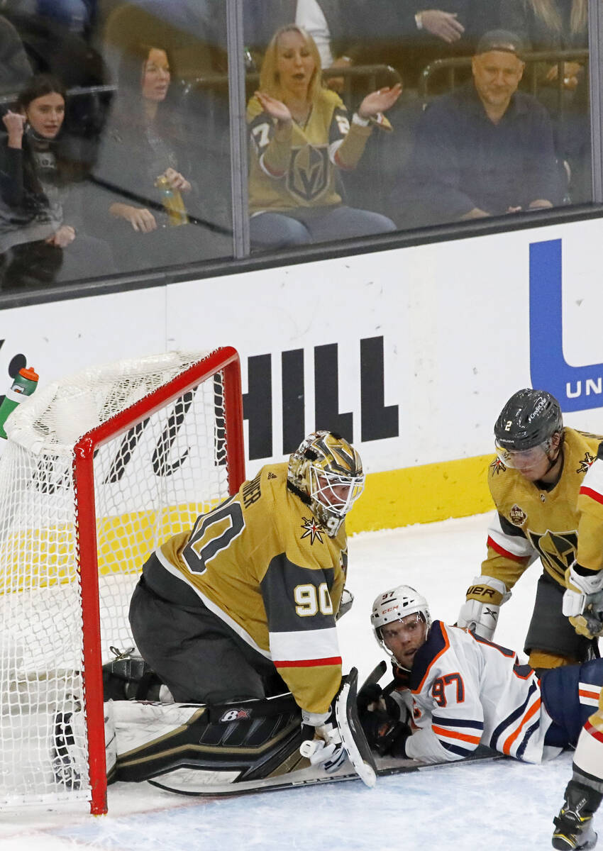 Edmonton Oilers center Connor McDavid (97) bumps into Golden Knights goaltender Robin Lehner (9 ...