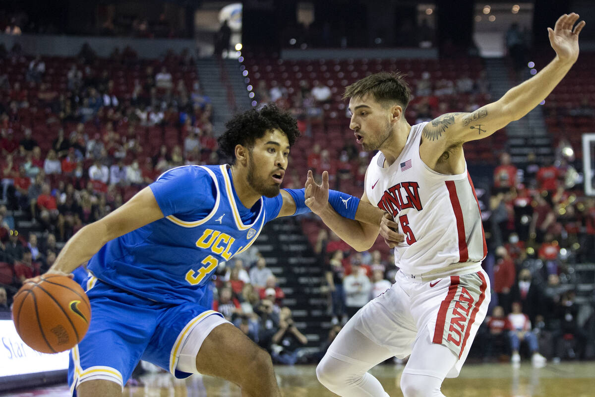 UCLA Bruins guard Johnny Juzang (3) dribbles around UNLV Rebels guard Jordan McCabe (5) during ...