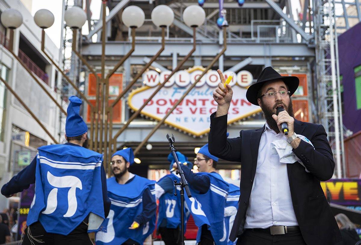 Rabbi Levi Harlig addresses the crowd during a celebration of the first night of Hanukkah with ...