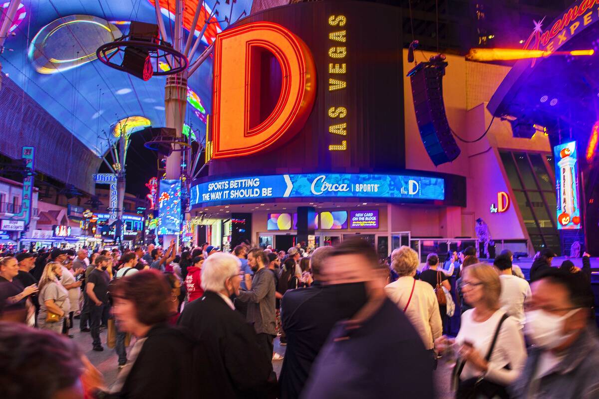 People walk past D Las Vegas on Fremont Street on Wednesday, Oct. 20, 2021, in Las Vegas. (Benj ...