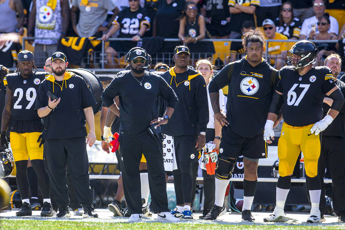 Pittsburgh Steelers head coach Mike Tomlin, center, stands with his hands on his hips on the si ...