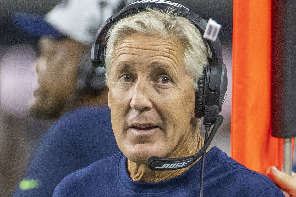 Seattle Seahawks head coach Pete Carroll tosses a piece of gum to a player on the sidelines dur ...
