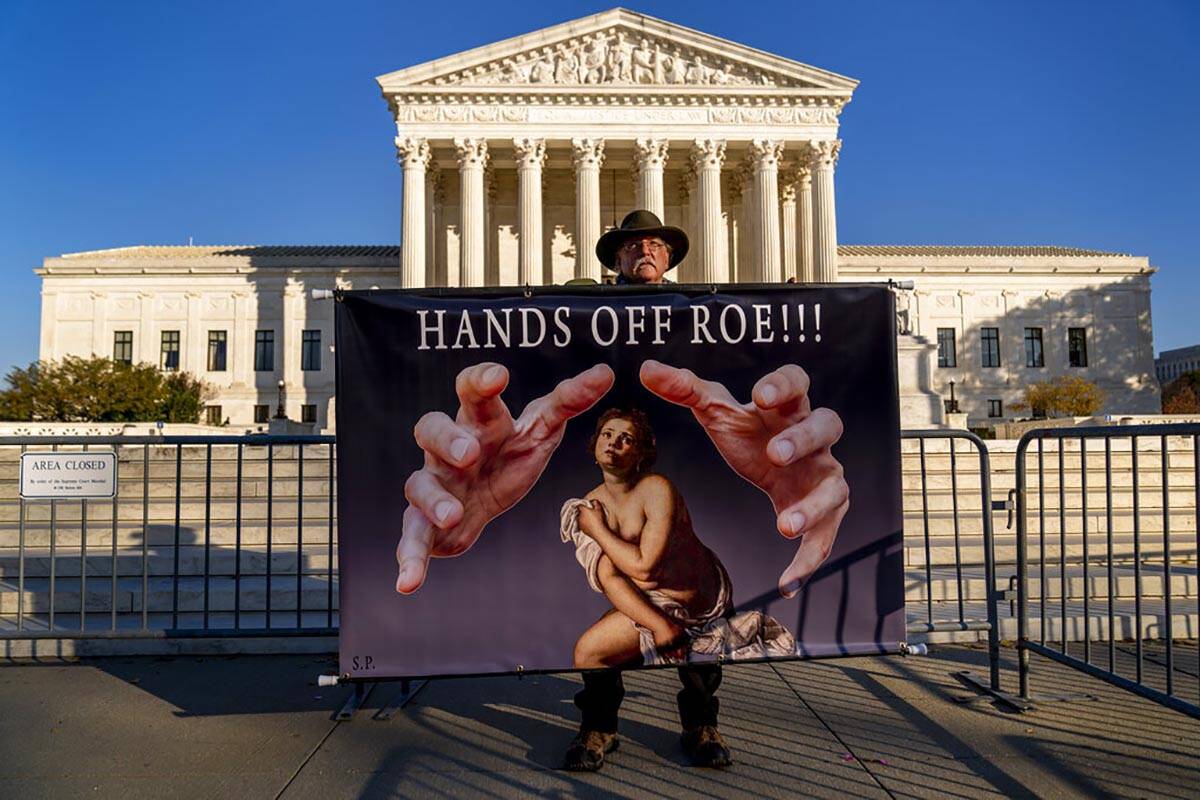 Stephen Parlato of Boulder, Colo., holds a sign that reads "Hands Off Roe!!!" outside ...