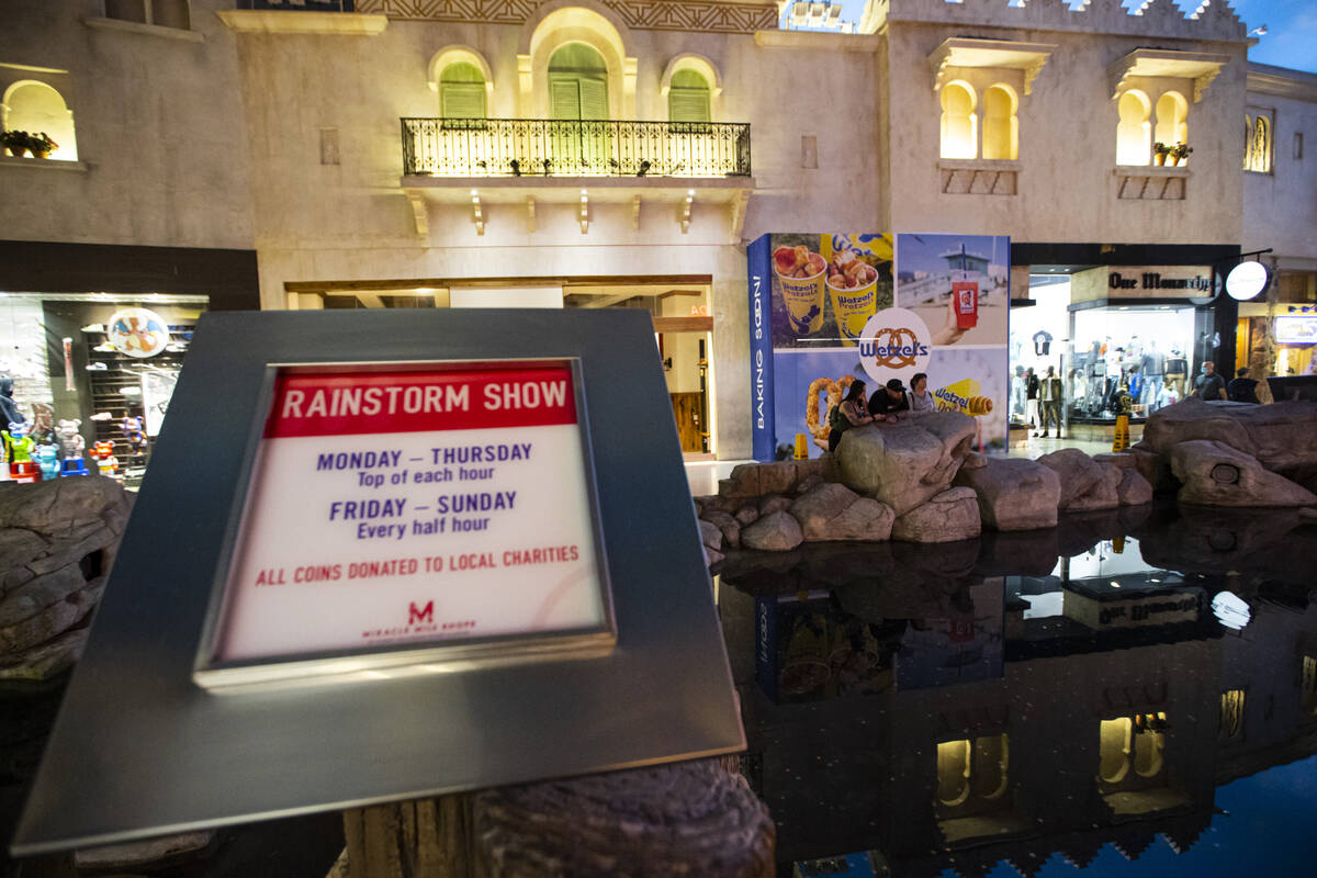 A sign promoting coins to be tossed during the rainstorm show is seen at the Miracle Mile Shops ...