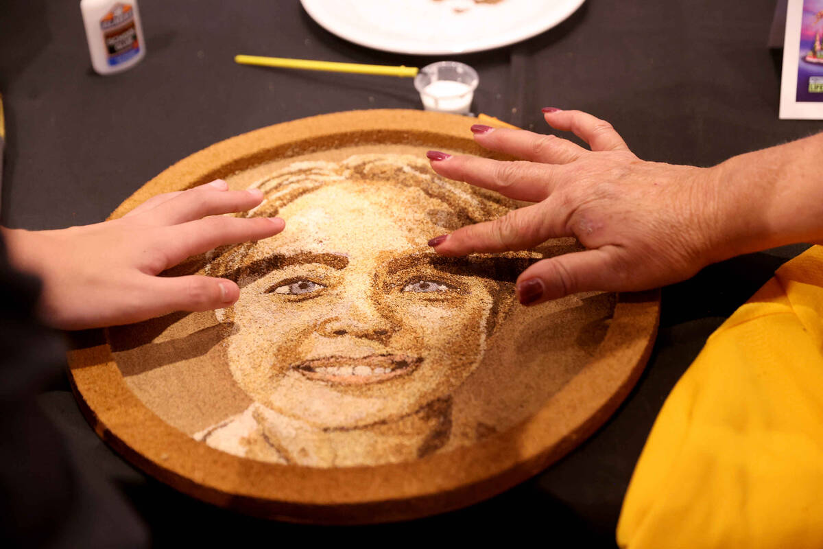 Loved ones put finishing touches on a floragraph of Alexander Bush during a ceremony honoring h ...