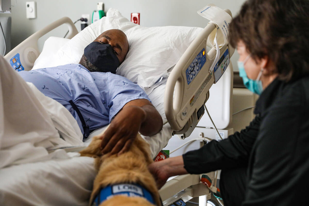 Wes Wallace, of Virginia, pets Lois, a comfort dog, alongside her caretaker Jennifer Pollock, a ...