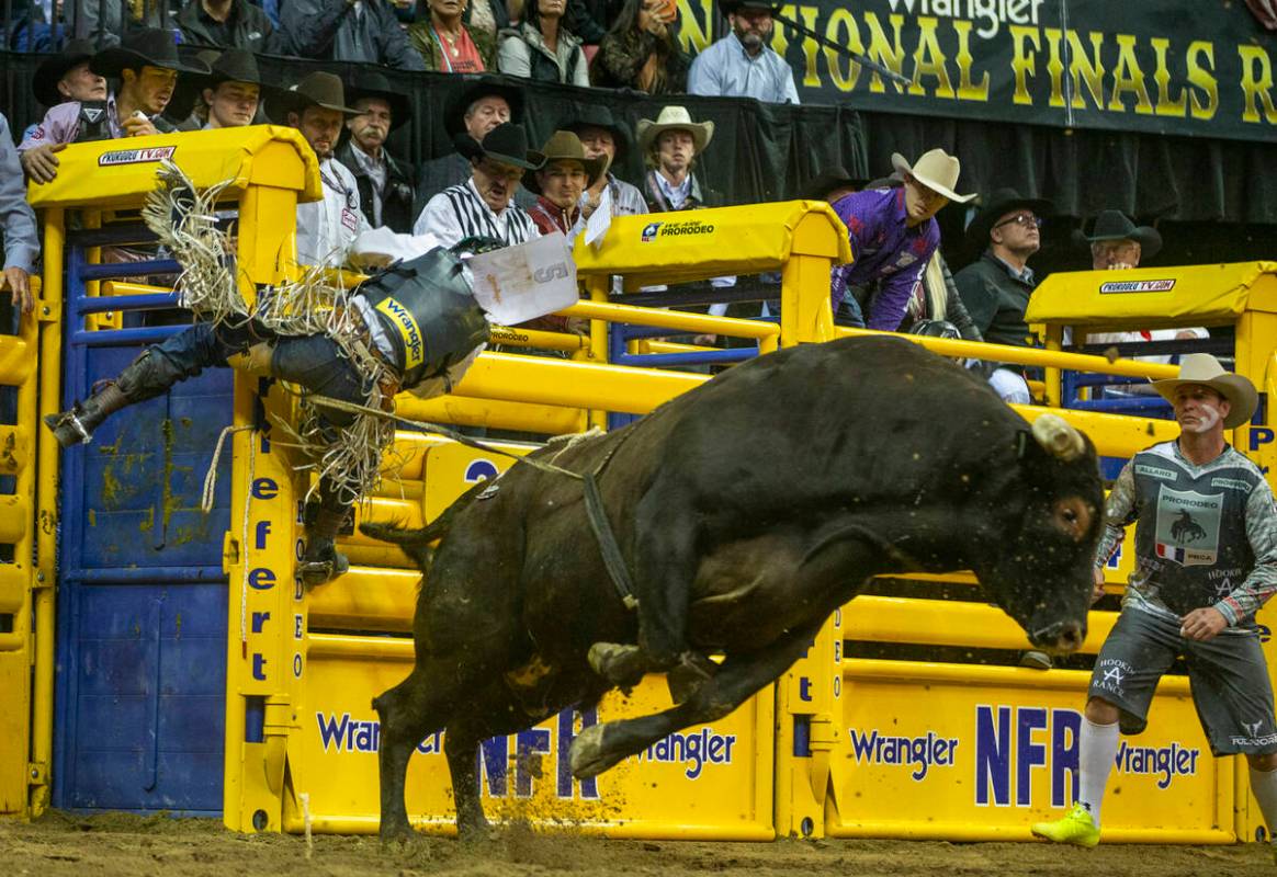 Stetson Wright of Milford, Utah, clings to the gate after being thrown from Pickup Man in Bull ...