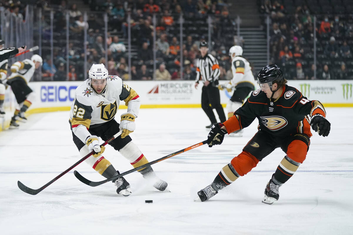 Vegas Golden Knights' Michael Amadio, left, moves the puck under defense by Anaheim Ducks' Cam ...