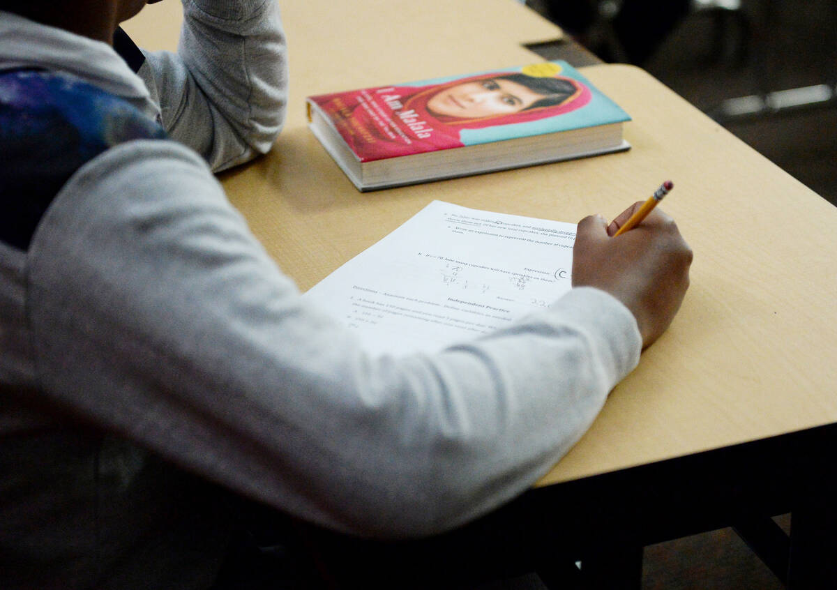 A sixth grade student writes down math problems during class at Democracy Prep in Las Vegas, Tu ...