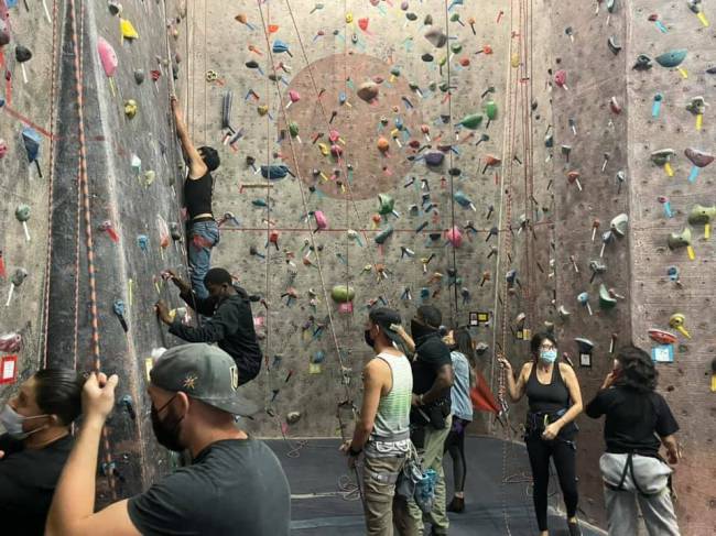 Youth participants in the Metropolitan Police Department's DREAM program teach indoor rock climbing...