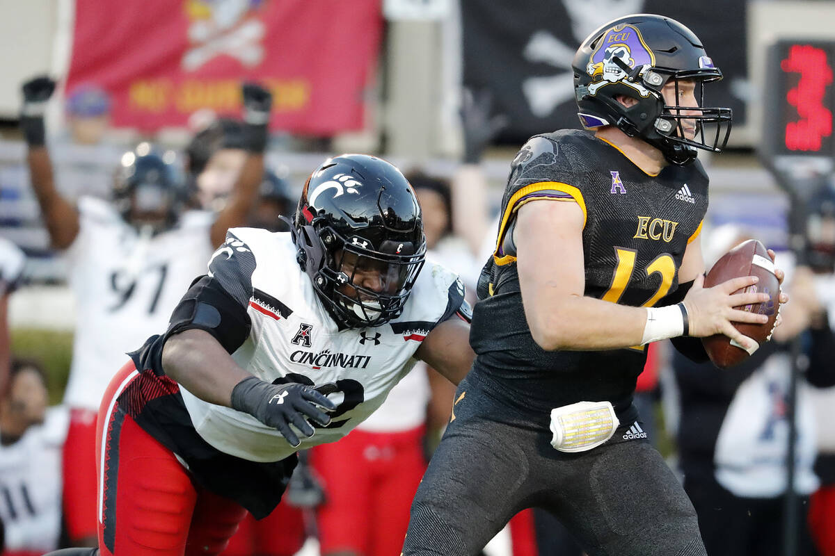 Cincinnati's Curtis Brooks (92) tries to take down East Carolina quarterback Holton Ahlers (12) ...