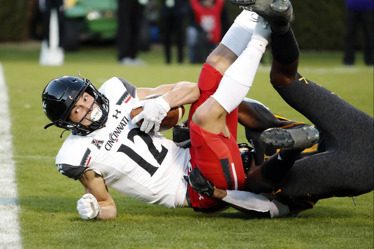 Cincinnati's Alec Pierce (12) stretches for extra yards against East Carolina during the first ...