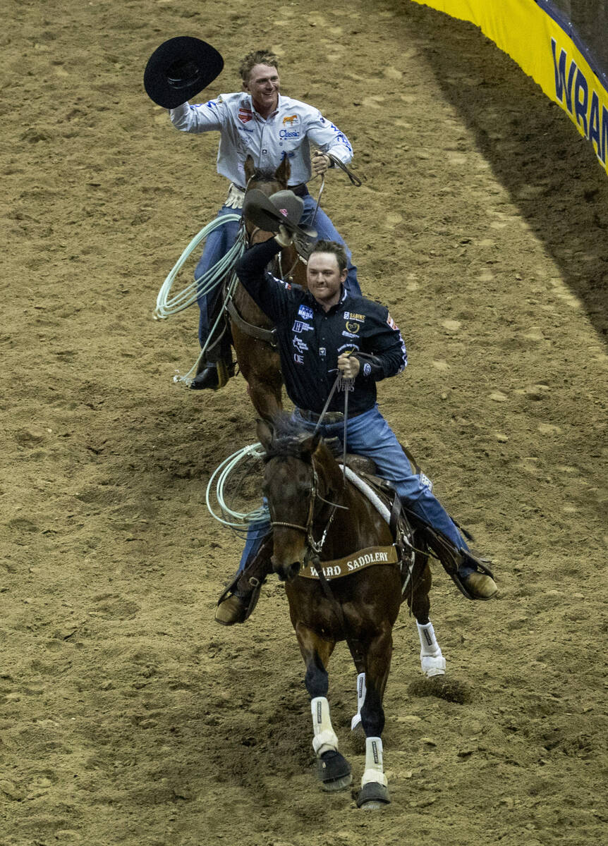 Tyler Wade of Terrell, TX., and Trey Yates of Pueblo, CO., celebrate their Team Roping win duri ...