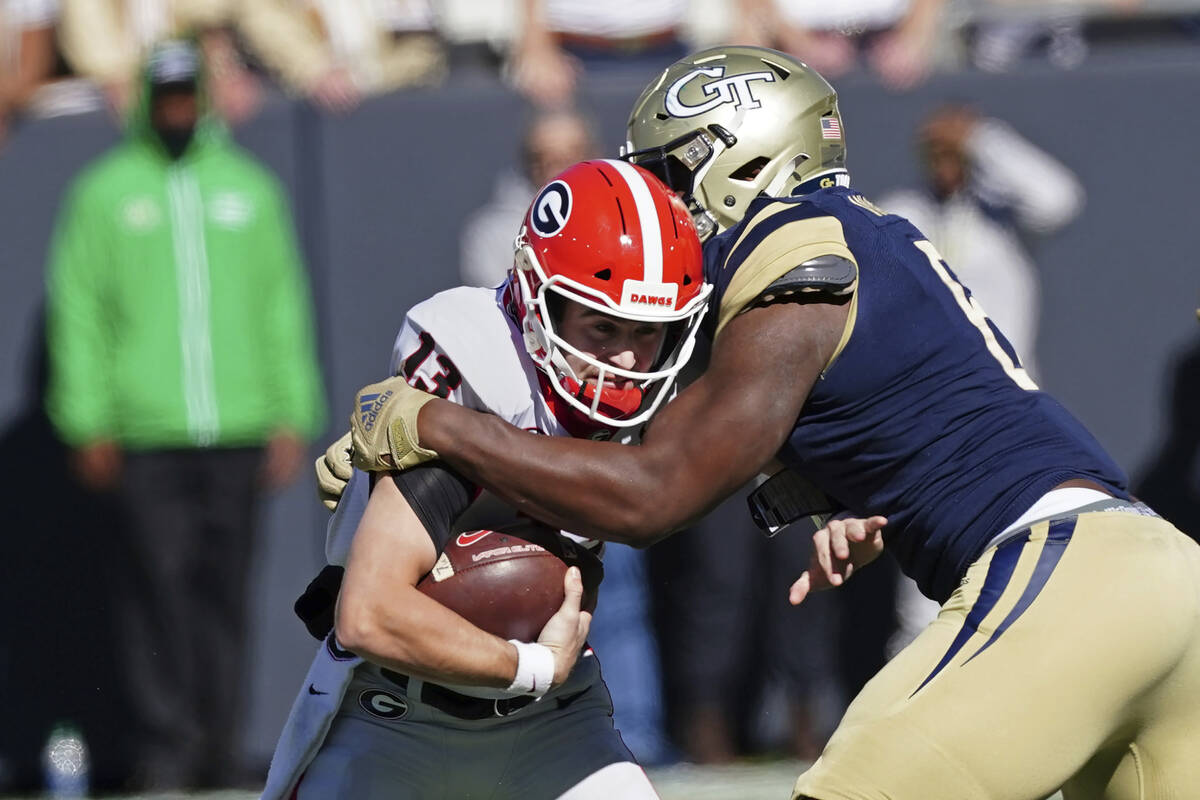 Georgia quarterback Stetson Bennett (13) is brought down by Georgia Tech defensive lineman Keio ...